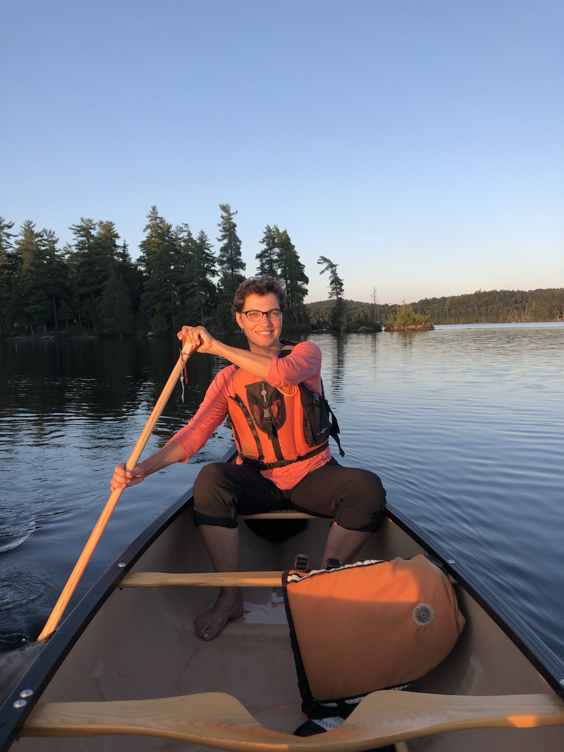 Trae Robinson paddling in the back of a canoe