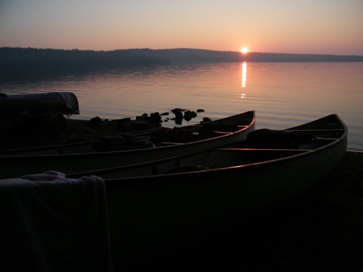 canoes at sunrise by the water